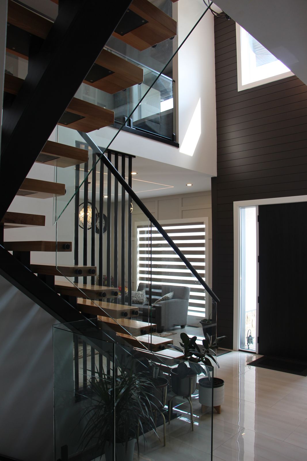Open staircase and glass railing beside floor-to-ceiling windows