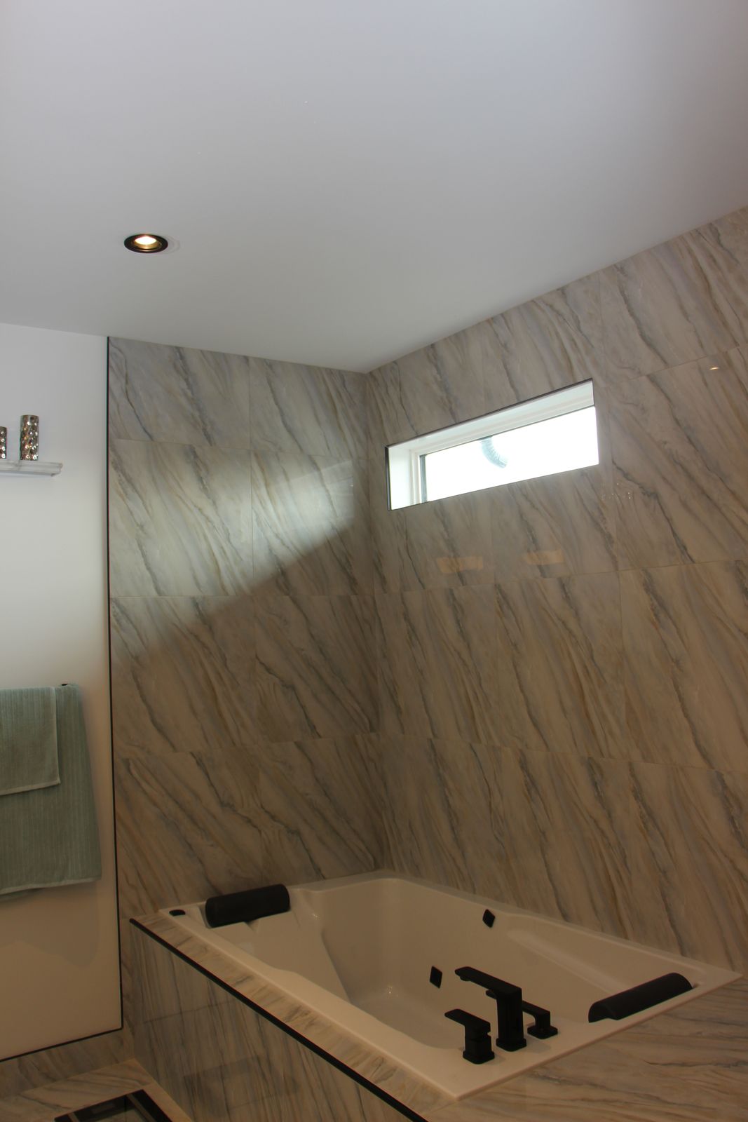 Ensuite soaker tub set against marble-look tile